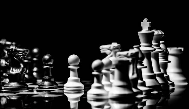istock Close up of Chess pieces on a reflective mirror board surface wi 1458698172