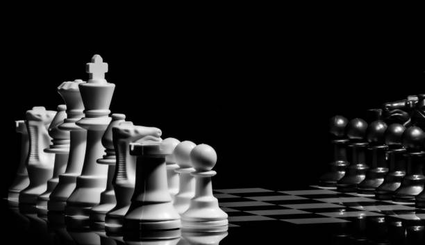 istock Close up of Chess pieces on a reflective mirror board surface wi 1458698185