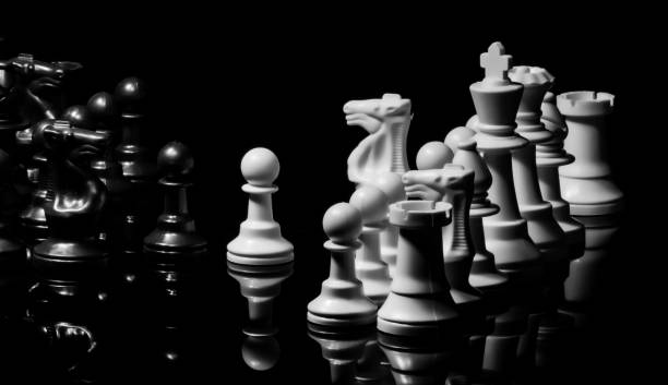 istock Close up of Chess pieces on a reflective mirror board surface wi 1458698245