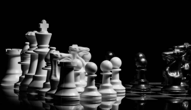istock Close up of Chess pieces on a reflective mirror board surface wi 1458698270