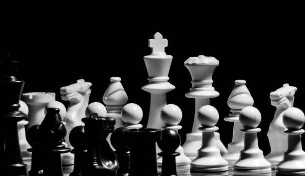 istock Close up of Chess pieces on a reflective mirror board surface wi 1458698332