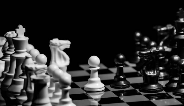 istock Close up of Chess pieces on a reflective mirror board surface wi 1458698420