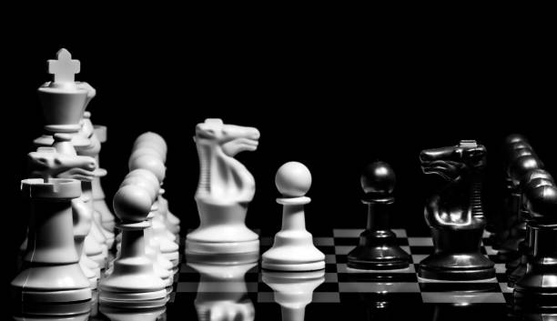 istock Close up of Chess pieces on a reflective mirror board surface wi 1458698424