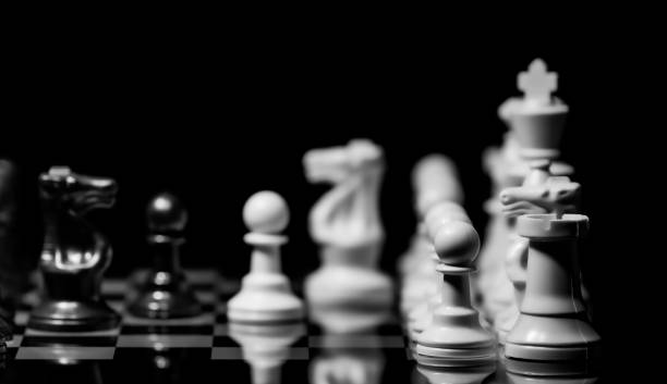 istock Close up of Chess pieces on a reflective mirror board surface wi 1458698449