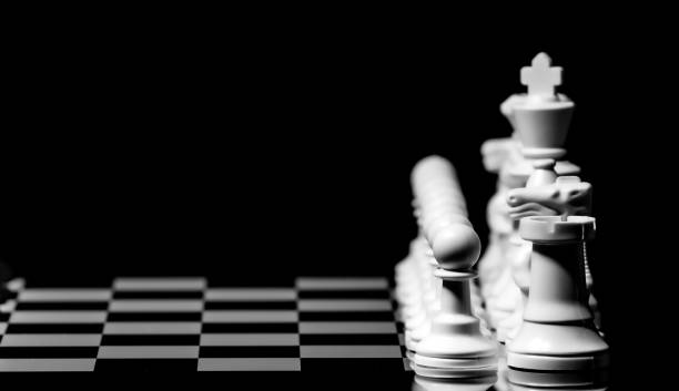 istock Close up of Chess pieces on a reflective mirror board surface wi 1458698489