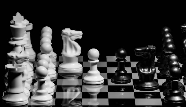 istock Close up of Chess pieces on a reflective mirror board surface wi 1458698548