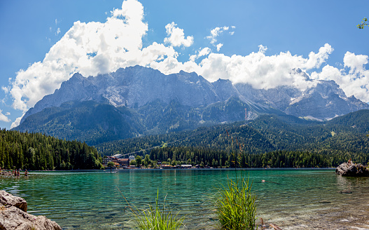 Lake in the mountains in summer. Beautiful Landscape scenery. Bavarian panorama of the beach of lake Eibsee, Bavaria Germany. Mountain range of the Wettersteingebirge in Background.