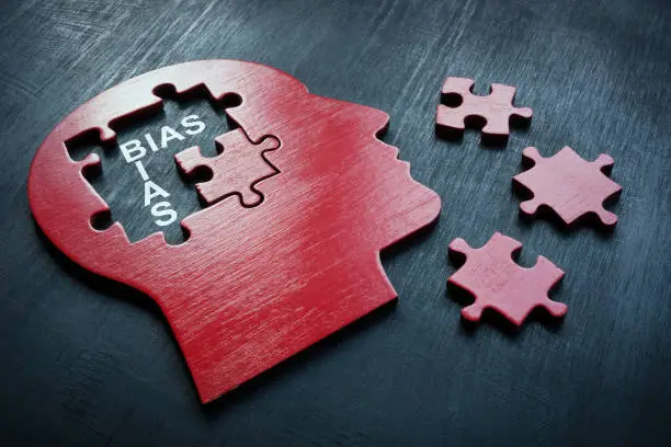 Photo of A Head with puzzle pieces and word bias.