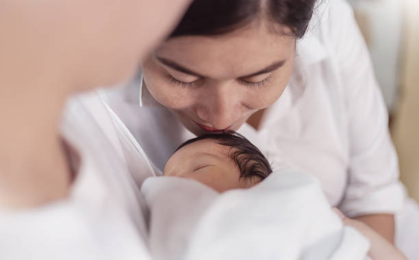 그녀의 신생아에게 키스하는 아름다운 젊은 아시아 어머니의 초상화. 의료 및 의료 인도 히스패닉 가족 사랑 라이프 스타일 아시아 어머니의 날 부모 개념 파노라마 배너 - native american baby love mother 뉴스 사진 이미지