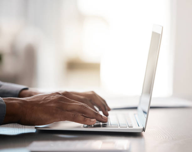 istock Closeup, hands and typing on laptop with black man at desk for email, communication or digital marketing in office. Zoom, businessman hand and keyboard on computer for strategy, planning or research 1458700956