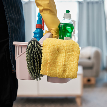 Cleaning product, chemical and basket with man in living room to clean bacteria, dust and dirt during spring cleaning at home. Cleaning service, cleaner or maid with container to work in room