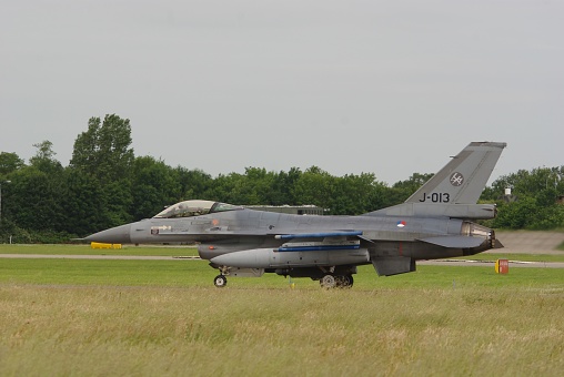 A F-104 fighter jet model in Blue scheme aggressor camouflage on right side carrying AIM-9 missiles on the wingtips.