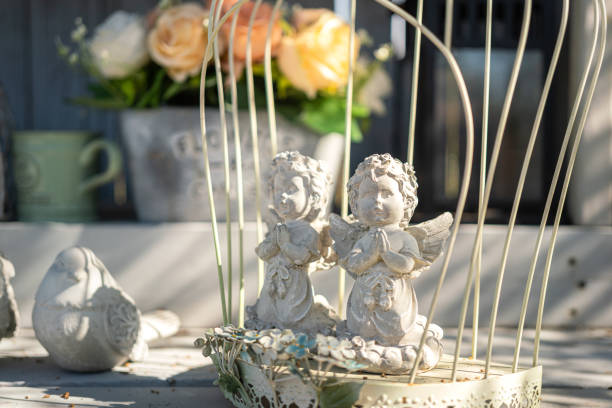 A couple of cute stone cupid which is placed on the table, decoration for wedding event. Close-up and selective focus at the one object.