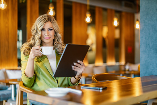 Attractive businesswoman in the cafe, using digital tablet and shopping online.People,business and technology concept.