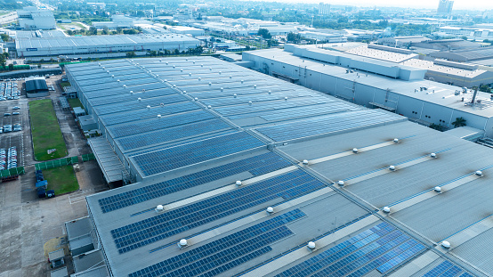 Top view Solar Cell on Warehouse Factory. Solar photo voltaic panels system power or Solar Cell on industrial building roof for producing green ecological electricity. Production of renewable energy.