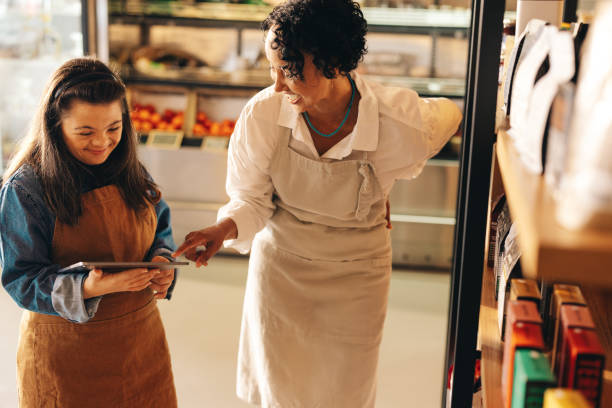 istock Cheerful grocery store owners using a digital tablet together 1458706597