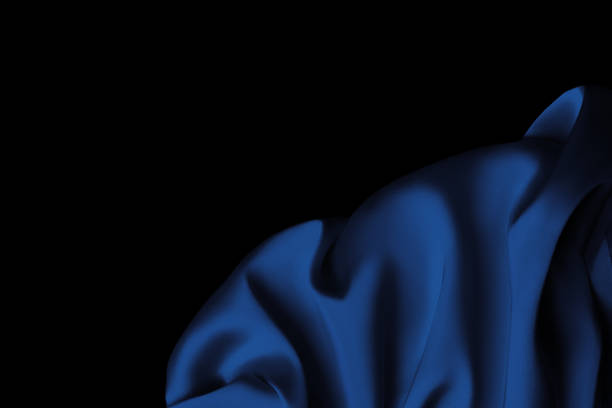 istock Blue satin fabric lays on the surface in the form of openwork folds, silk background, satin background 1458706951