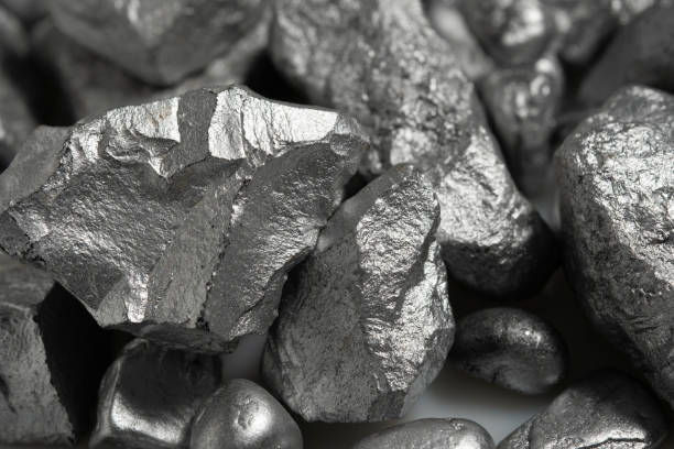klumpen aus silber oder platin oder seltenerdmineral auf einem boden - erz stock-fotos und bilder
