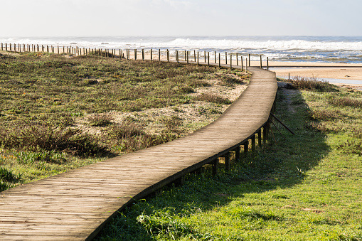 Wooden footpath through the dunes to the beach of praia de Silvalde , Portugal