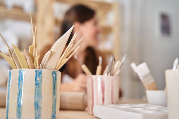 istock Young woman in an art workshop decorating a clay plate 1458709371