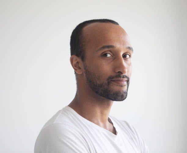 istock A young unshaven man on a light gray background. African American. 1458710852