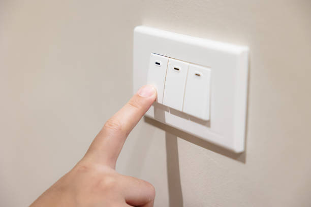 istock people press light switch to turn off the light for saving home energy reduce utilities billing cost 1458711217