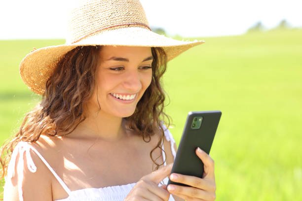 istock Happy woman using phone in a field on summer 1458715049