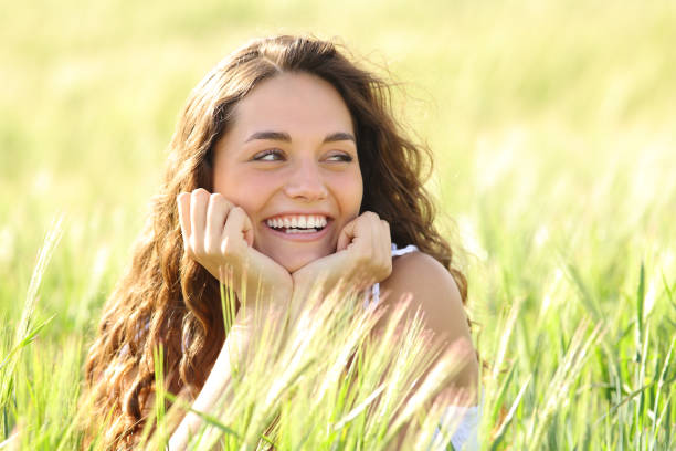 mulher feliz sincera sorrindo em um campo - candid women portrait human face - fotografias e filmes do acervo