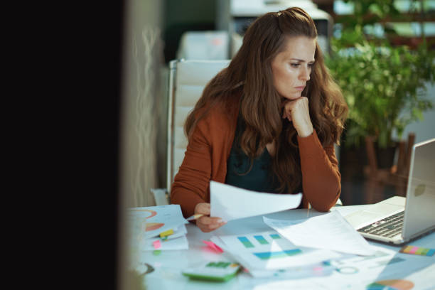 istock business owner woman in green office working with documents 1458719406