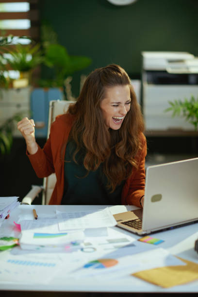 istock smiling business owner woman working with documents rejoicing 1458719410