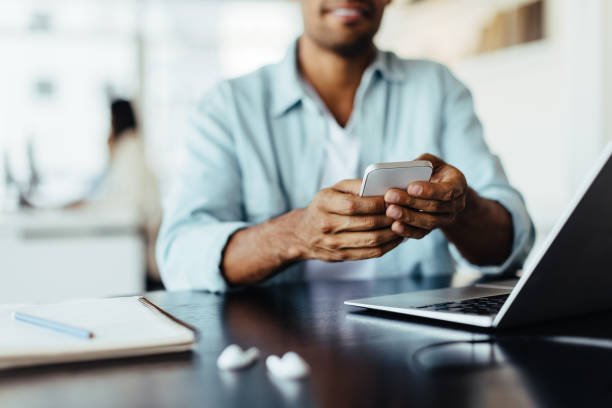 istock Man sitting in an office and using a mobile phone 1458720070