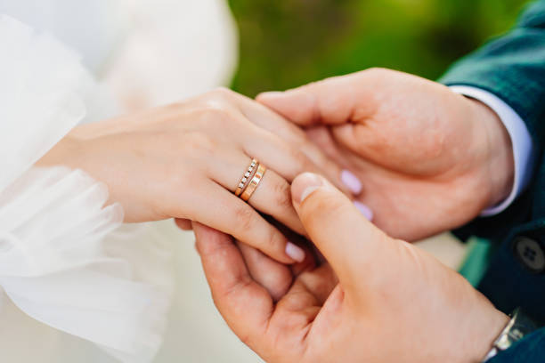 istock a man's hand holds a woman's hand with a wedding ring on her finger. 1458720103