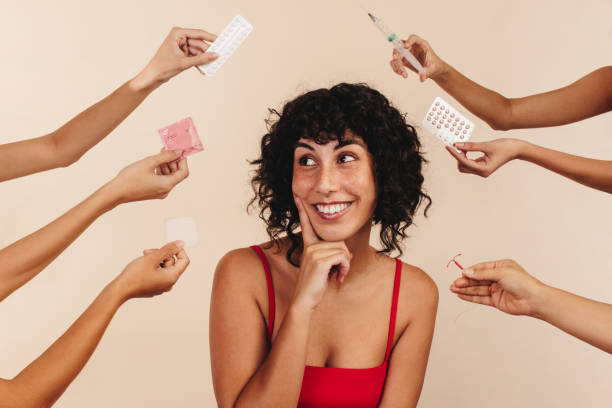 happy woman in studio with hands offering birth control options - sex education condom contraceptive sex imagens e fotografias de stock