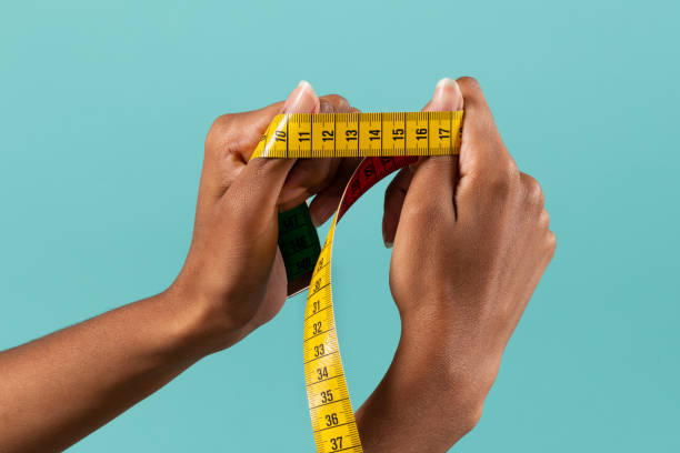 istock Black female hands showing measuring tape 1458722135