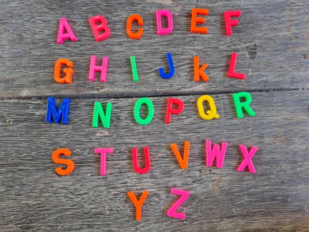 istock Plastic magnetic letters isolated on wood background, top view. 1458722972