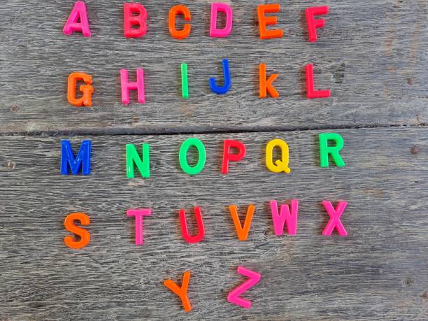 istock Plastic magnetic letters isolated on wood background, top view. 1458724462