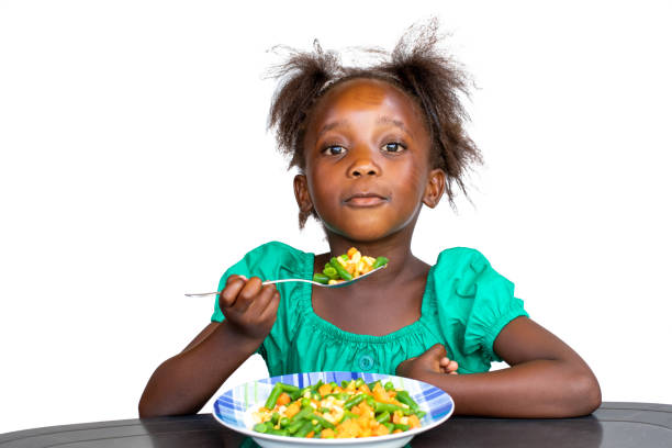 istock Cute little african kid eating mixed vegetable dish 1458724889