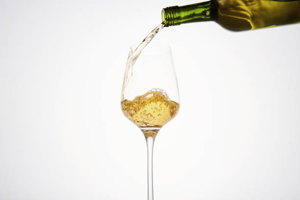 istock White wine pouring from green bottle, close up. 1458726735