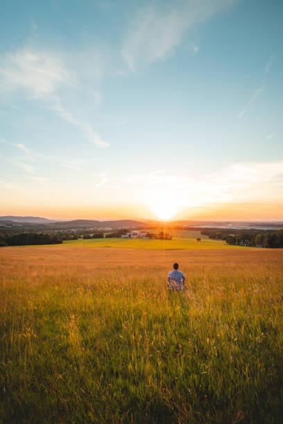 istock Man sitting in a cornfield thinks about his future looking into the sunset. Self-education, mastering mindfulness. Beskydy mountains, Czech Republic 1458726810
