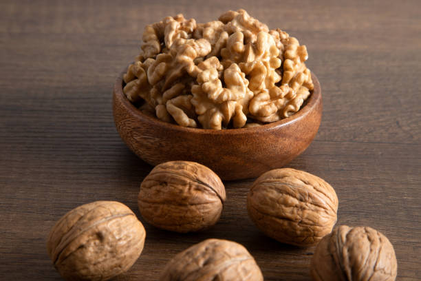 istock Peeled walnuts and whole walnuts on wooden background 1458727292