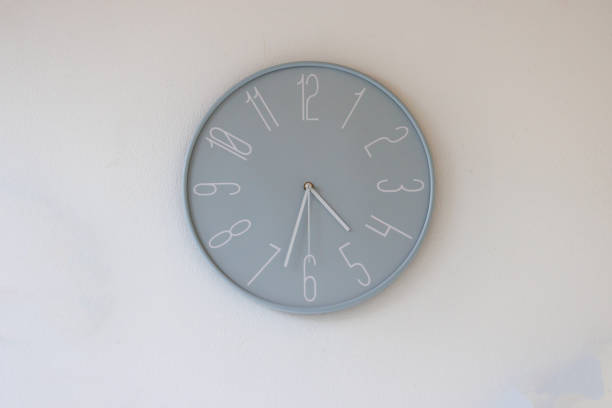 blue plastic clock on white wall in the kid school. blue pastel clock wall.