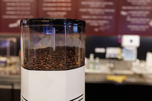 grinder coffee machine. Coffee beans inside the machine hopper of coffee shop.