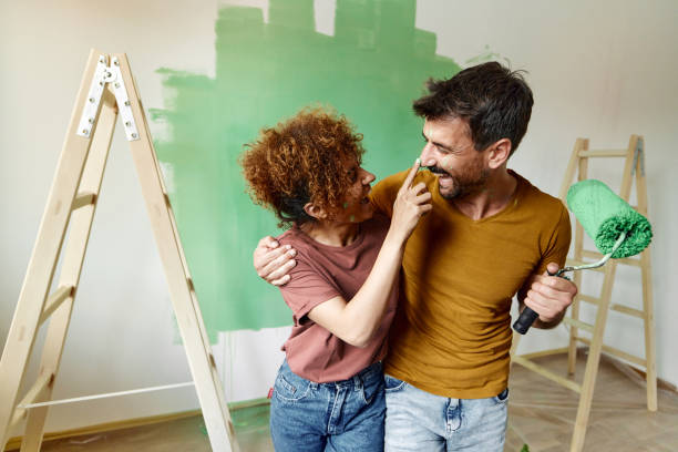 istock Cheerful couple having fun while painting their new home. 1458728508