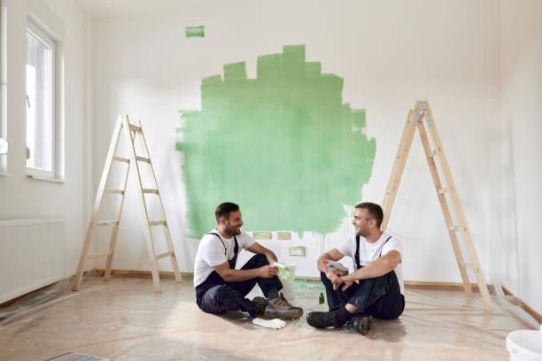istock Happy manual workers talking on a break inside of renovating apartment. 1458729537