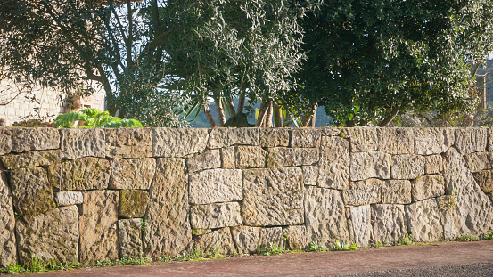 Rustic stone wall in house garden fence