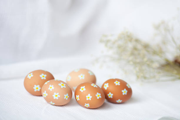 istock Easter eggs of natural color with painted tiny flowers on them. 1458733029