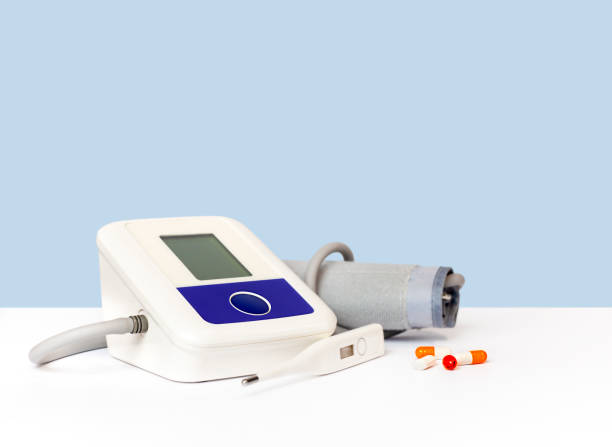 istock Tonometer, thermometer and pills on the table on a blue background 1458736129