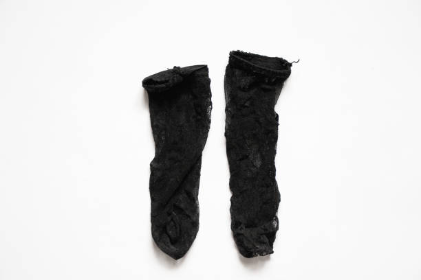long black nylon dirty socks on a white background, old women's knee socks