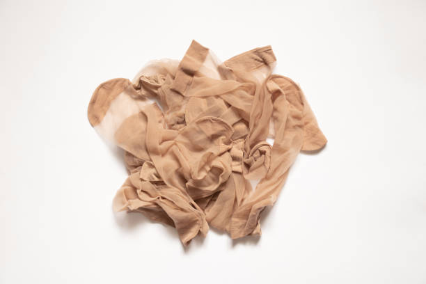 uma pilha de meias velhas e sujas de nylon brown em um fundo branco, meia de nylon, meias femininas - silk stockings - fotografias e filmes do acervo