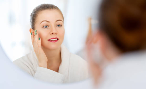 istock woman with cream for her face 1458738701